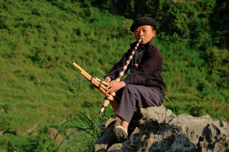 Ha Giang / Vietnam - 31/10/2017: Local Vietnamese boy playing a traditional instrument in the North Vietnamese region of Ha Giang royalty free stock photography Ha Giang / Vietnam - 31/10/2017: Local Vietnamese boy playing a traditional instrument in the North Vietnamese region of Ha Giang royalty free stock photography