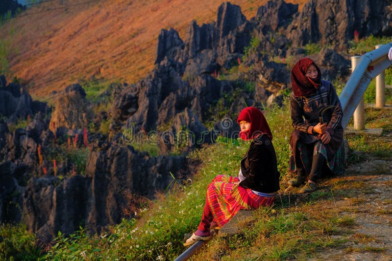 Ha Giang / Vietnam - 01/11/2017: Two local Vietnamese women in traditional clothes looking at the sunrise and mountain scenery in stock photos Ha Giang / Vietnam - 01/11/2017: Two local Vietnamese women in traditional clothes looking at the sunrise and mountain scenery in stock photos