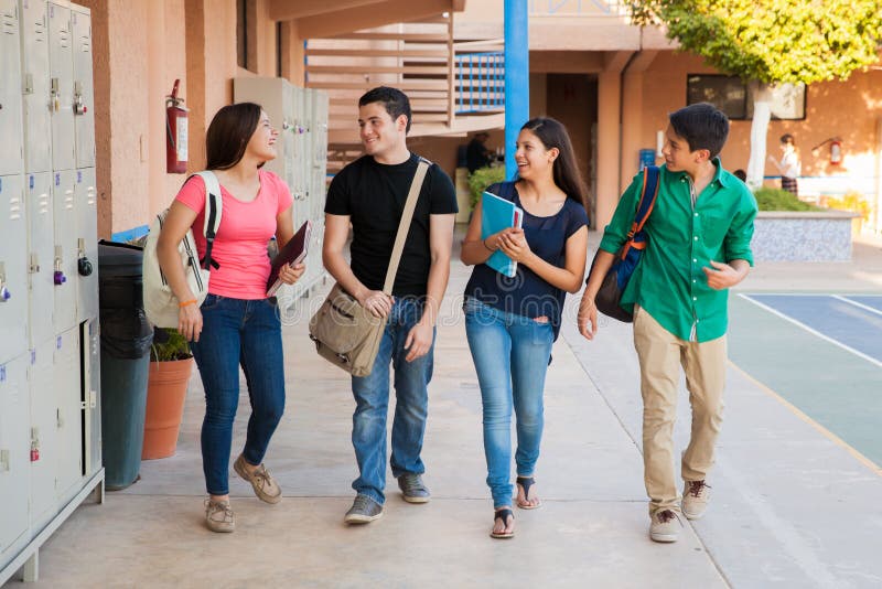 Group of high school students talking and laughing in a hallway between classes. Group of high school students talking and laughing in a hallway between classes