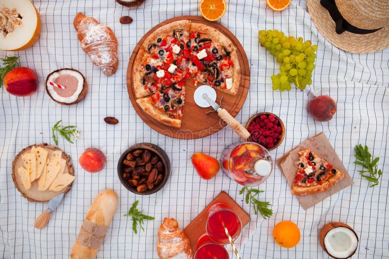 Ha picknick på stranden på solnedgången i den vita plädet, maten och drinken royaltyfria foton Ha picknick på stranden på solnedgången i den vita plädet, maten och drinken royaltyfria foton