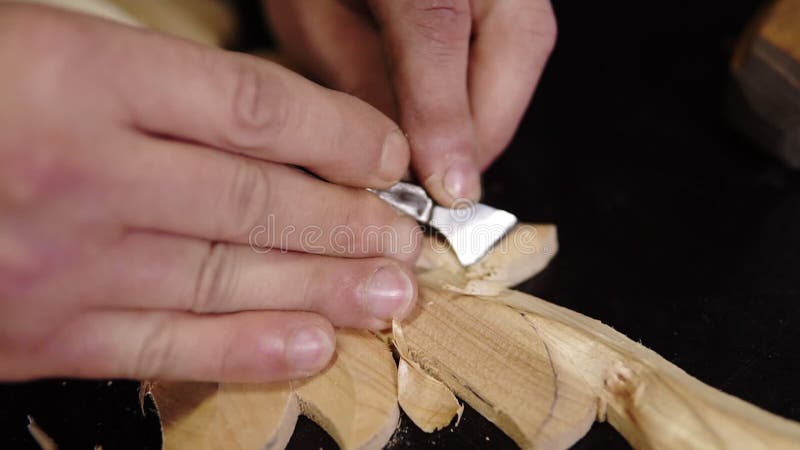 Ha realizzato un filmato sulle mani di ma' e sta curando un piccolo dettaglio sulla sagoma di legno - ornamento floreale in opera