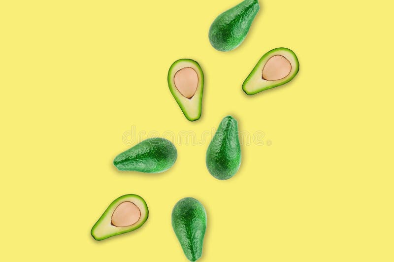 Ha sparso i tutti e le metà freschi dell'avocado organico con i noccioli nel centro della tavola gialla in cucina o nel mercato immagine stock libera da diritti Ha sparso i tutti e le metà freschi dell'avocado organico con i noccioli nel centro della tavola gialla in cucina o nel mercato immagine stock libera da diritti