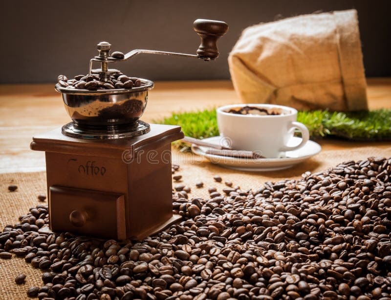 Habas de la amoladora de café y taza de café fotografía de archivo Habas de la amoladora de café y taza de café fotografía de archivo