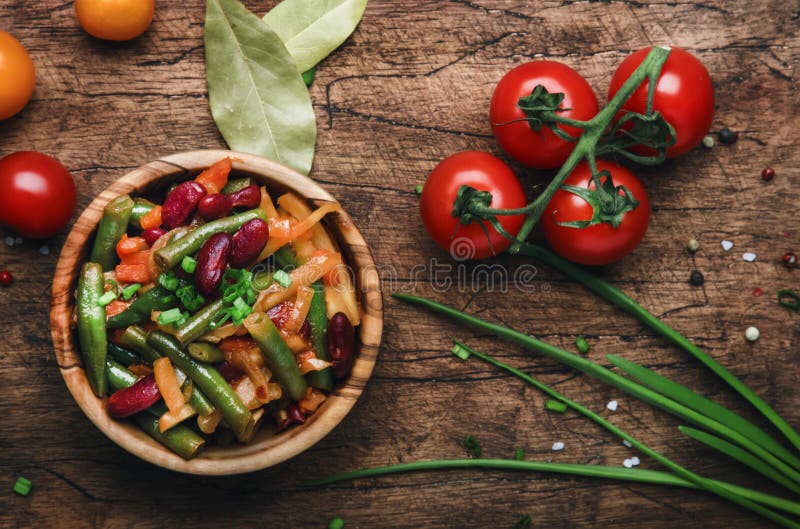 Habas verdes con las raíces, verduras, setas, especias y tomates, cena del vegano Comida que come el fondo, rústico de madera del fotografía de archivo libre de regalías Habas verdes con las raíces, verduras, setas, especias y tomates, cena del vegano Comida que come el fondo, rústico de madera del fotografía de archivo libre de regalías