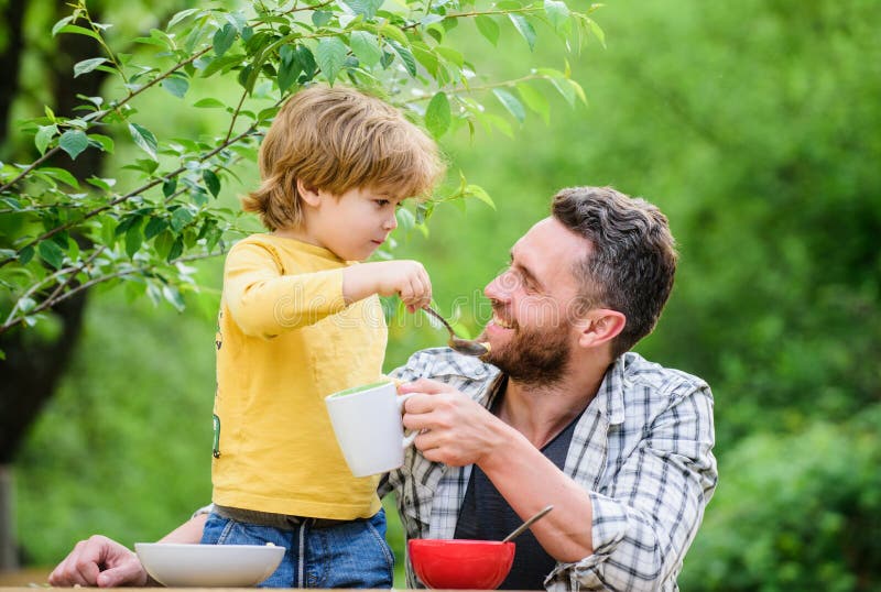 habitudes alimentaires Peu gar?on avec le papa mangeant le fond de nature de nourriture Concept sain de nourriture de petit d?jeu images stock habitudes alimentaires Peu gar?on avec le papa mangeant le fond de nature de nourriture Concept sain de nourriture de petit d?jeu images stock
