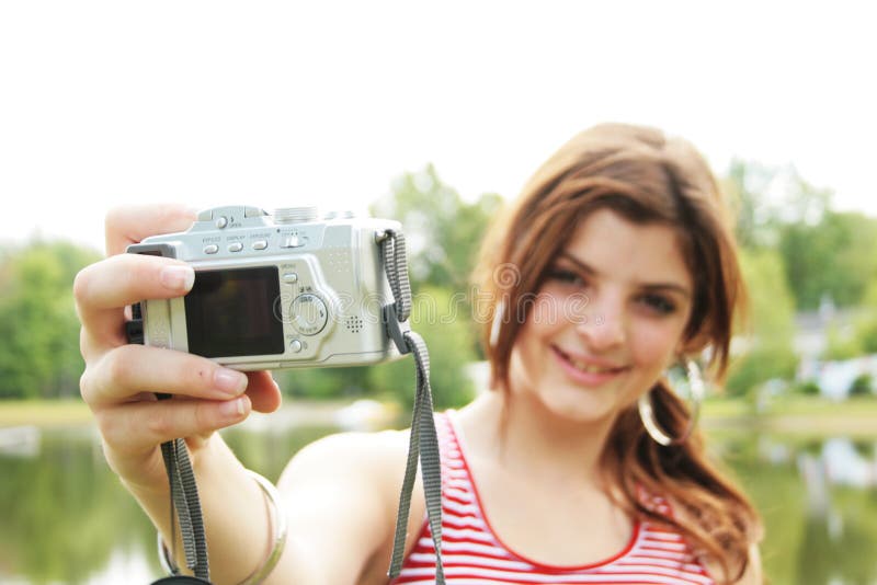 Pretty teenager with camera taking a picture of herself. Pretty teenager with camera taking a picture of herself