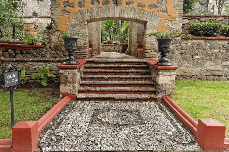 A stone mosaic on the floor, a stair with an arch framed by two large ceramic vases in a typical hacienda garden. City of Guanajuato, mexican colonial heartland, Mexico. A stone mosaic on the floor, a stair with an arch framed by two large ceramic vases in a typical hacienda garden. City of Guanajuato, mexican colonial heartland, Mexico.