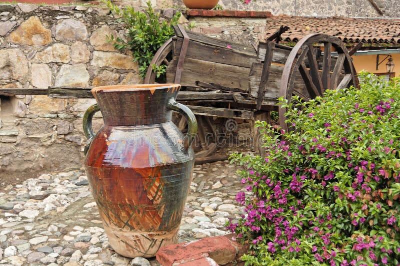 Flowers, a vase and an old wood charriot in a typical hacienda garden. City of Guanajuato, mexican colonial heartland, Mexico. Flowers, a vase and an old wood charriot in a typical hacienda garden. City of Guanajuato, mexican colonial heartland, Mexico.