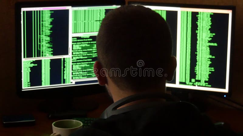Hacker breaking code and drinking from the cup at your desk. Criminal hacker penetrating network system from his dark stock photo Hacker breaking code and drinking from the cup at your desk. Criminal hacker penetrating network system from his dark stock photo