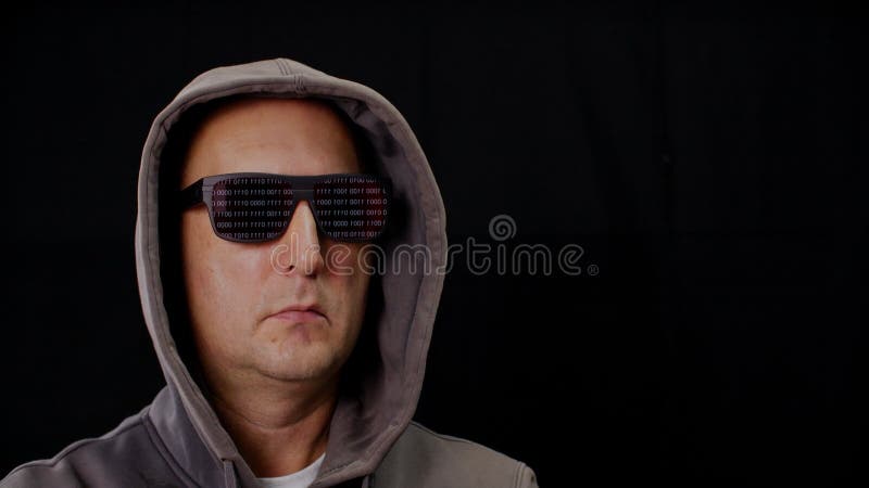 Hacker de computadora en gafas de sol negro y carnosas que reflejan código binario en fondo negro. retrato masculino en gafas oscu