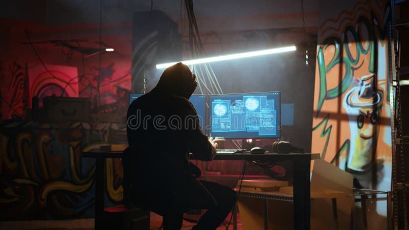 Hacker en ubicación oculta con paredes de graffiti usando pc para implementar malware fotografía de archivo libre de regalías