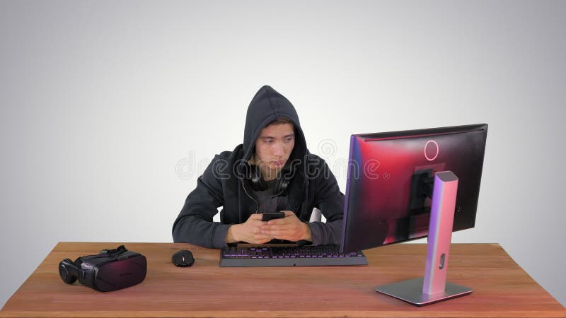 Hacker encapuchado usando laptop y smartphone sobre fondo degradado. almacen de video