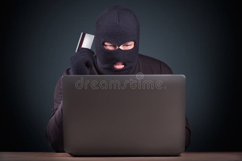 Hacker holding a credit card royalty free stock photo