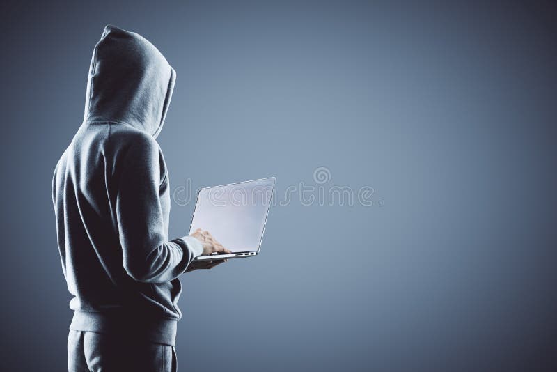 Hacker holding laptop stock photography