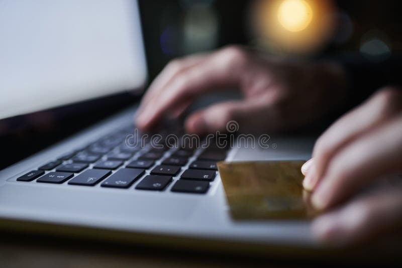 Hacker, laptop and credit card fraud for hacking, cloning and identity theft with person typing at night. Hands, tech royalty free stock photo