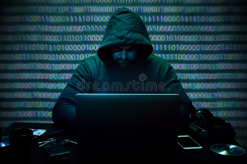Hacker-Programmierer mit Computer in Dunkelkammer stockfoto