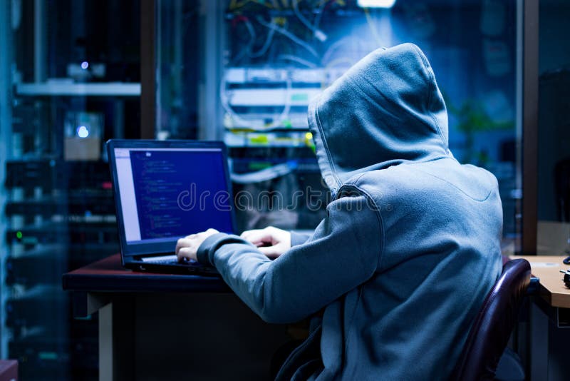 Dangerous Hooded Hacker Breaks into Government Data Servers and Infects Their System with a Virus. His Hideout Place has Dark Atmosphere. Dangerous Hooded Hacker Breaks into Government Data Servers and Infects Their System with a Virus. His Hideout Place has Dark Atmosphere
