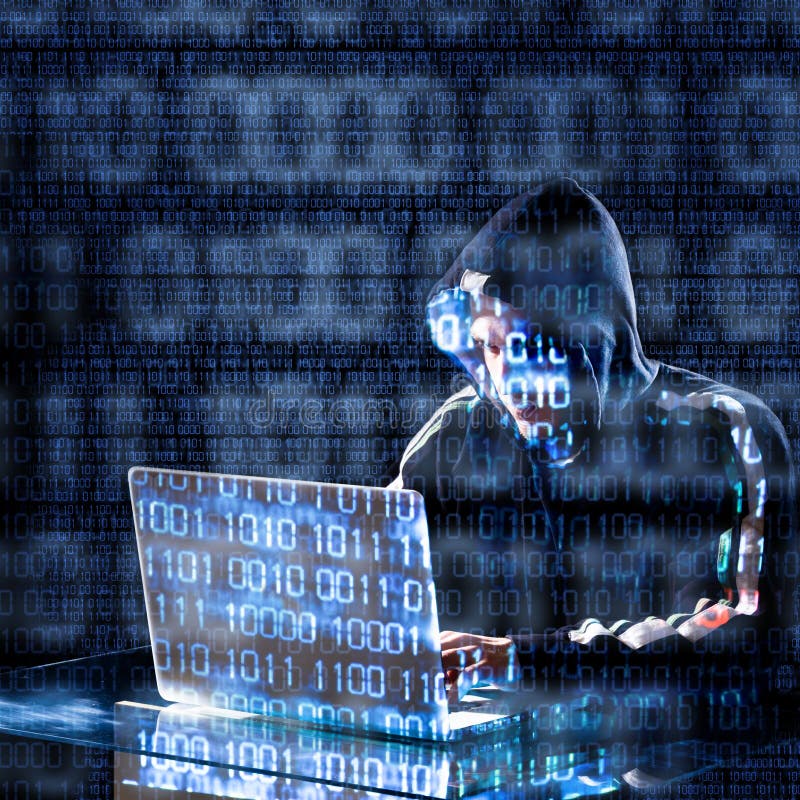 Hacker typing on a laptop stock photo