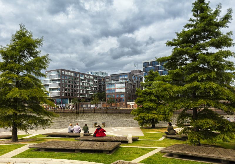 Tourists sit on a bench and look in the direction of the newly built Hafencity in Hamburg stock photo Tourists sit on a bench and look in the direction of the newly built Hafencity in Hamburg stock photo