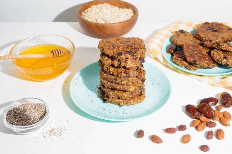 Hafermehlbananenpfannkuchen mit chia Samen-Mandelpflaumen und Daten gegossen mit Honig und wehgetan Schalenfrüchten auf einem hell stockbilder