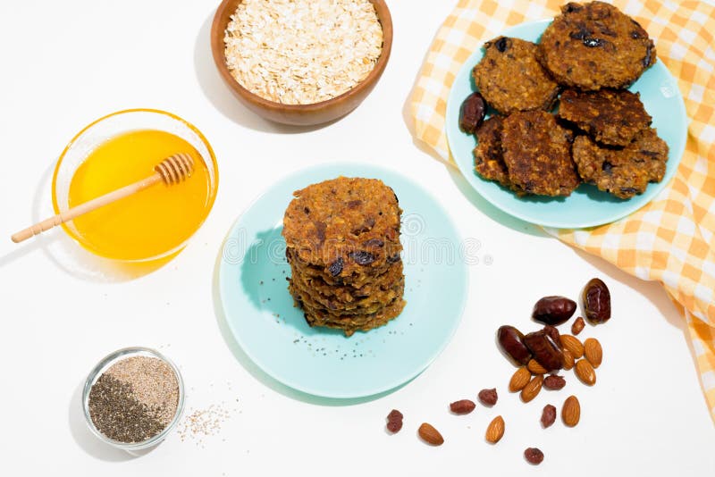 Hafermehlbananenpfannkuchen mit chia Samen-Mandelpflaumen und Daten gegossen mit Honig und wehgetan Schalenfrüchten auf einem hell lizenzfreies stockfoto