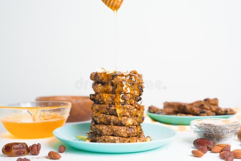Hafermehlbananenpfannkuchen mit chia Samen-Mandelpflaumen und Daten gegossen mit Honig und wehgetan Schalenfrüchten auf einem hell stockbild