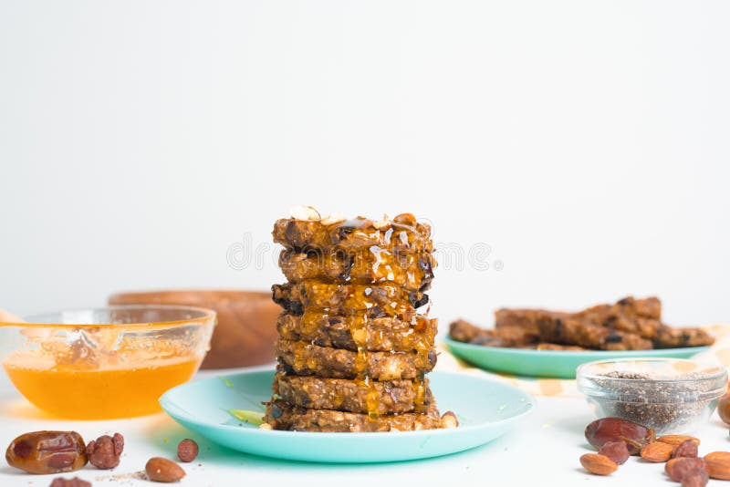 Hafermehlbananenpfannkuchen mit chia Samen-Mandelpflaumen und Daten gegossen mit Honig und wehgetan Schalenfrüchten auf einem hell lizenzfreie stockbilder