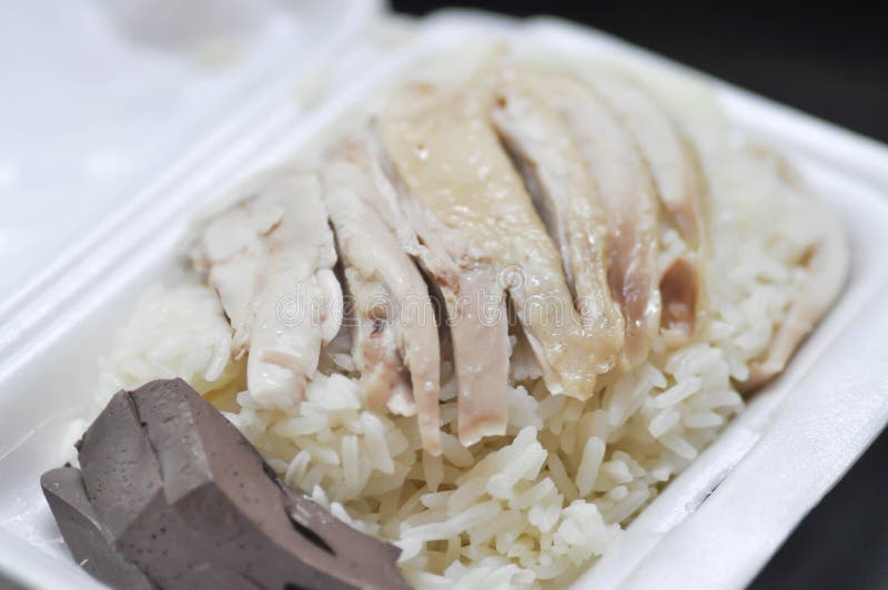 Hainanese chicken rice , rice topped with chicken in a box