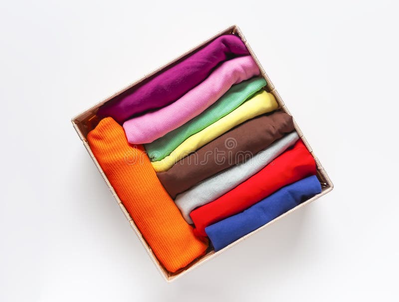 Haine pliate colorate într-o cutie. organizare acasă. stocare internă pe verticală. îmbrăcăminte pliată colorată în cutie.