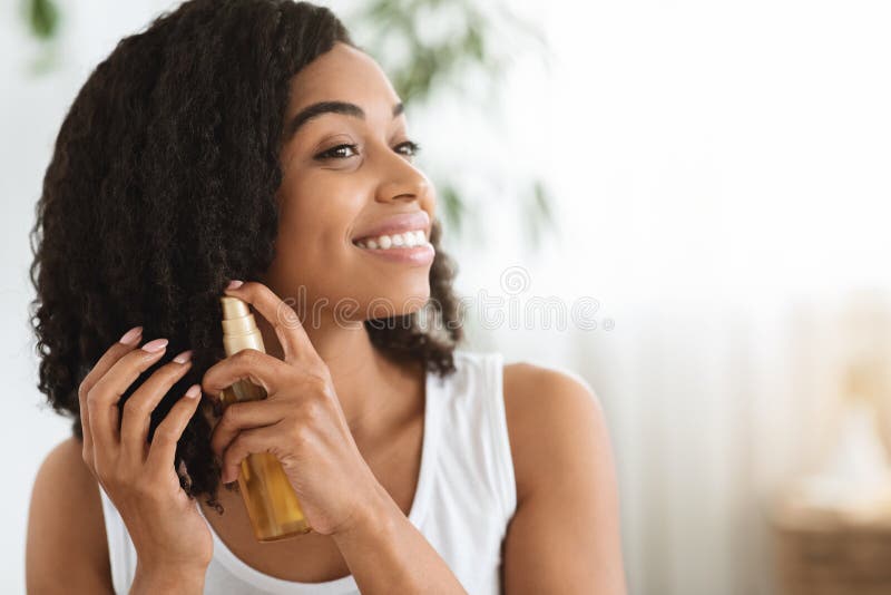 Hair Care. Happy Afro Woman Using Oil For Split Ends At Home stock images
