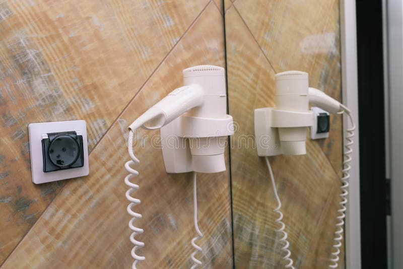 Hair Dryer on the Wall with Socket and Mirror. Electric Hair Dryer in