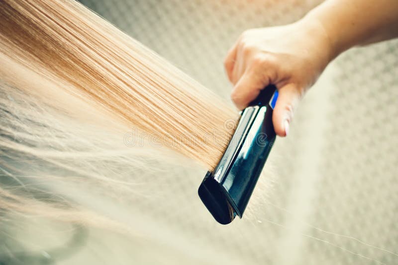 The hairdresser dries and combs a long fair hair. Hairdressing salon. royalty free stock image The hairdresser dries and combs a long fair hair. Hairdressing salon. royalty free stock image