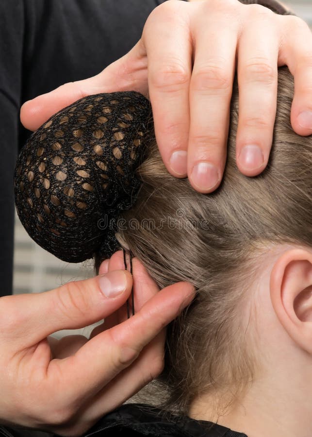 Hairdresser inserts a hairpin under the hairnet, close-up royalty free stock photos Hairdresser inserts a hairpin under the hairnet, close-up royalty free stock photos