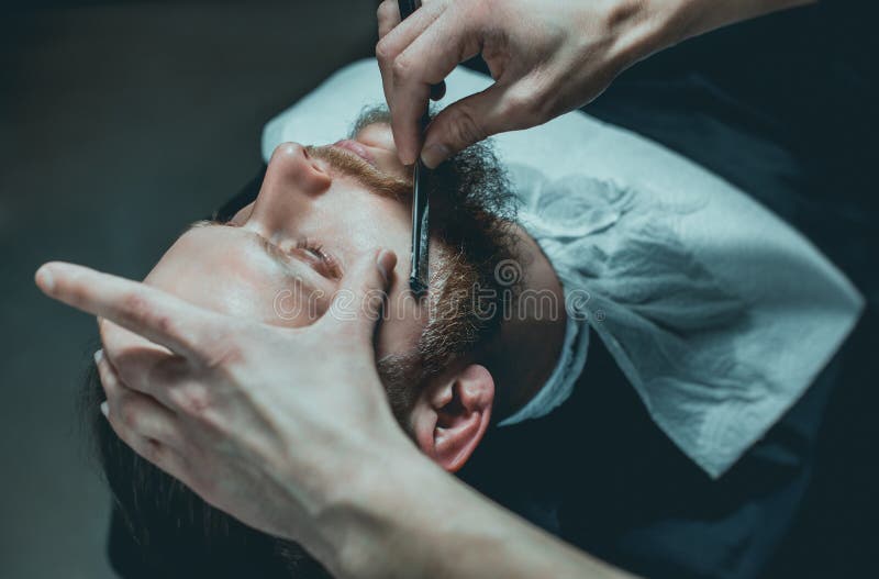 A hairdresser makes a man a haircut of his beard stock images A hairdresser makes a man a haircut of his beard stock images