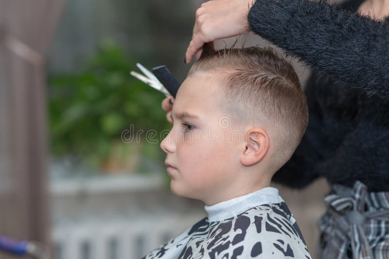 Side View Hairdresser Makes a Stylish Hairstyle. the Woman is Standing and  Making Haircut for Blonde Boy Stock Photo - Image of head, beauty: 196476984