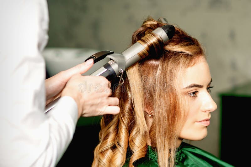 Hairdresser Using Curling Tongs Curls Long Brown Hair on the Young  Caucasian Girl in a Beauty Salon. Stock Image - Image of hairdressing,  beautician: 222886867