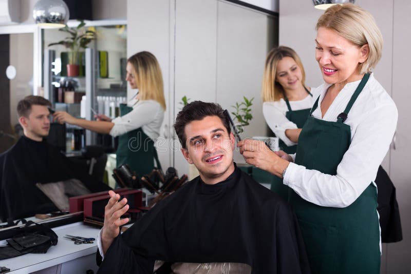 Positivo maduro rubio mujer cabello de chico en peluquería.