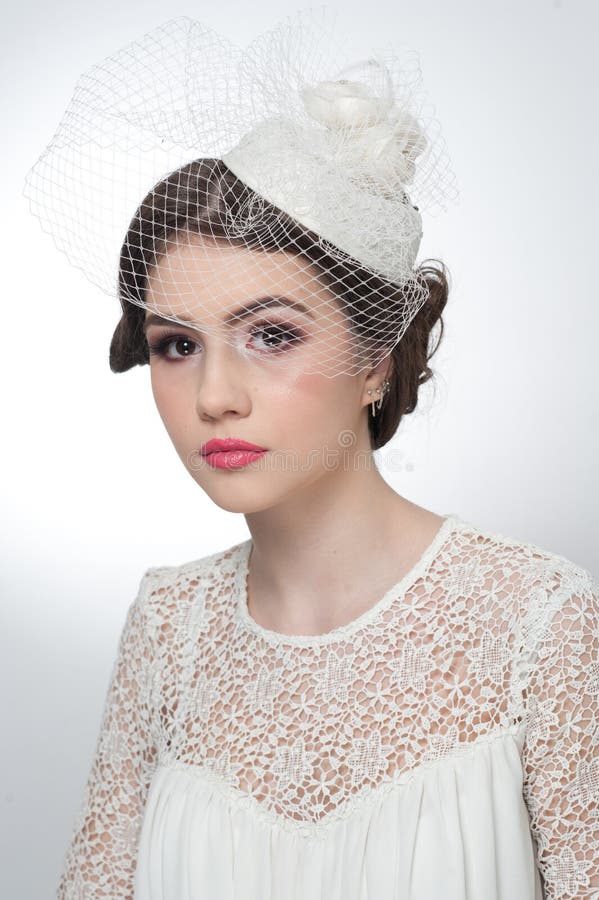 Hairstyle and make up - beautiful young girl art portrait. Cute brunette with white cap and veil, studio shot. Attractive girl royalty free stock photos Hairstyle and make up - beautiful young girl art portrait. Cute brunette with white cap and veil, studio shot. Attractive girl royalty free stock photos