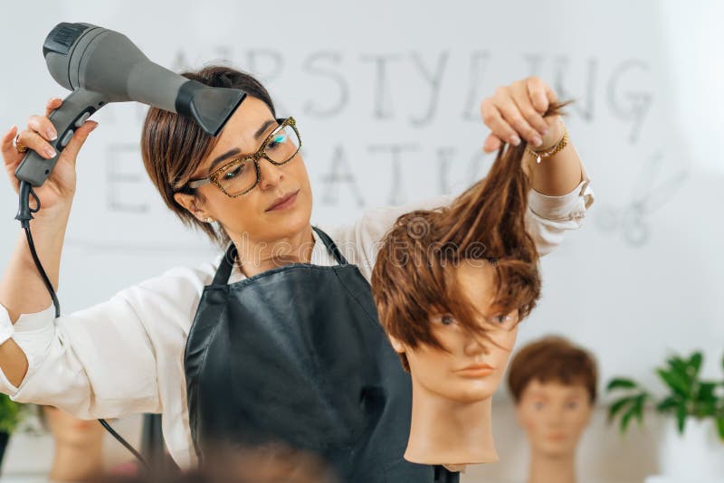 Hairstylist with the Hair Dryer in Hands Explaining Hairstyling Techniques,  Using Mannequin Head Stock Image - Image of hair, hand: 227452363