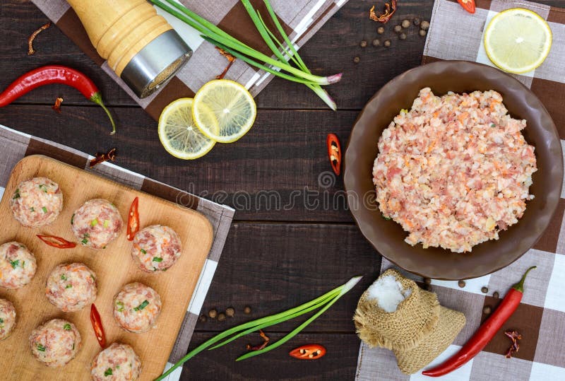 Hak, kruiden, groene uien - de ingrediënten voor de voorbereiding van vleesballen op een donkere houten achtergrond fijn royalty-vrije stock fotografie Hak, kruiden, groene uien - de ingrediënten voor de voorbereiding van vleesballen op een donkere houten achtergrond fijn royalty-vrije stock fotografie