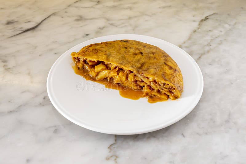 Halb saftiges Kartoffelomelett mit Zwiebel und Fleisch auf weißem Teller lizenzfreie stockfotografie