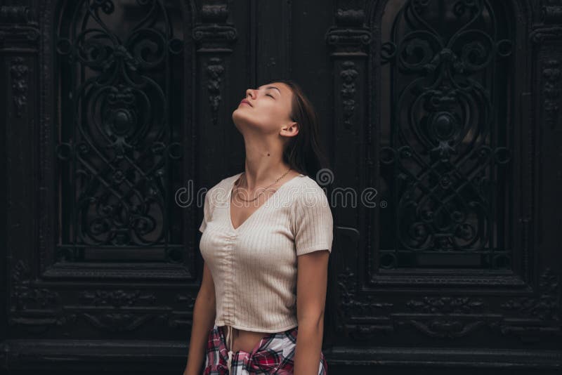 Halblänges Portrait von jungen schönen Brunette Mädchen in whit T-Shirt, das mit geschlossenen Augen und erhoehem Kopf steht lizenzfreies stockbild Halblänges Portrait von jungen schönen Brunette Mädchen in whit T-Shirt, das mit geschlossenen Augen und erhoehem Kopf steht lizenzfreies stockbild