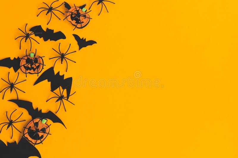 Halbröckige Ebene. moderne Kürbiskugel oder Laternenspinnen Fledermäuse ragen auf orangefarbenem Hintergrund mit Platz für Text. J lizenzfreies stockfoto