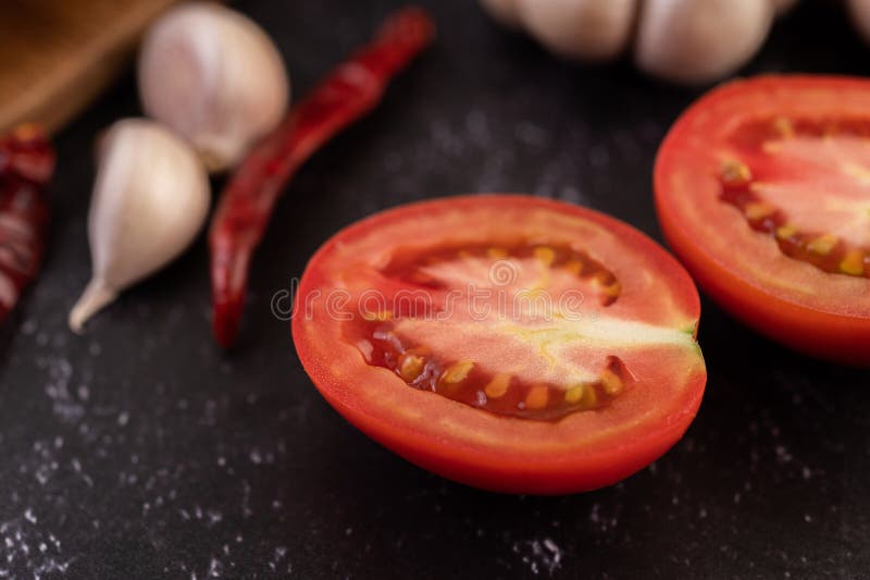 Halfcut Tomatoes on the Ground with Chili and Garlic Stock Image