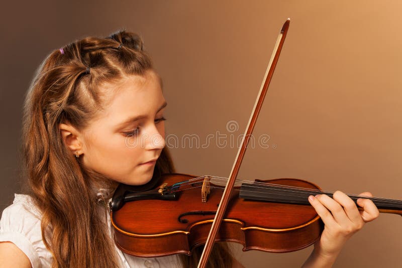 Half-face view of beautiful girl playing violin