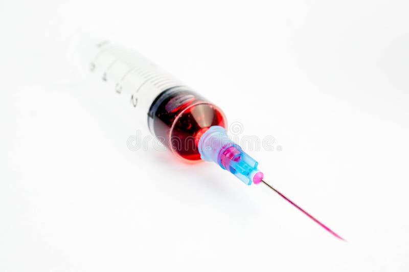 Half-filled syringe with red color liquid with needle pointing out