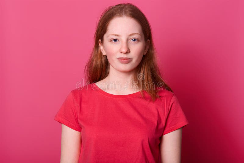 Half lengh portrait of young student female looks with calm facial expression at camera, wearing red casual t shirt, has long stock photo Half lengh portrait of young student female looks with calm facial expression at camera, wearing red casual t shirt, has long stock photo