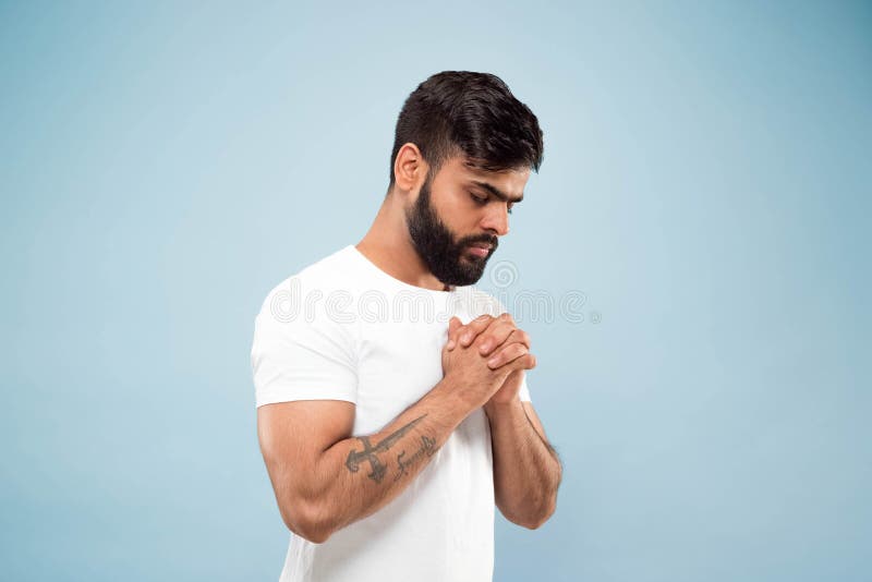 Half-length close up portrait of young man on blue background. stock photo Half-length close up portrait of young man on blue background. stock photo