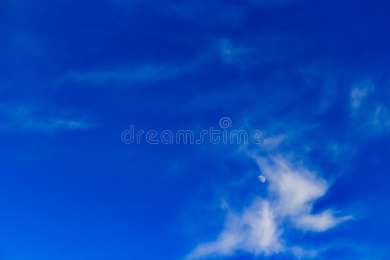 Half moon amidst wispy clouds stock photo Half moon amidst wispy clouds stock photo
