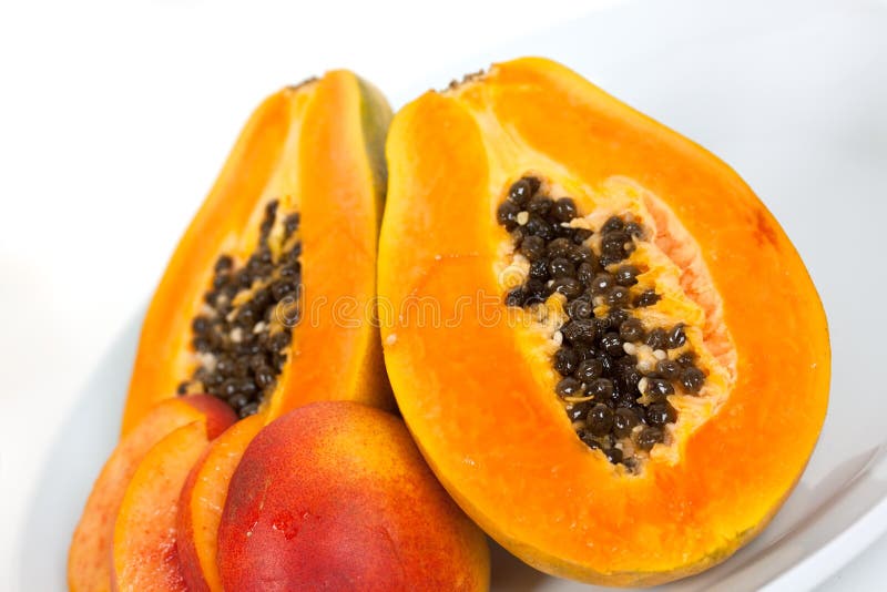 Half papaya on a wooden background.